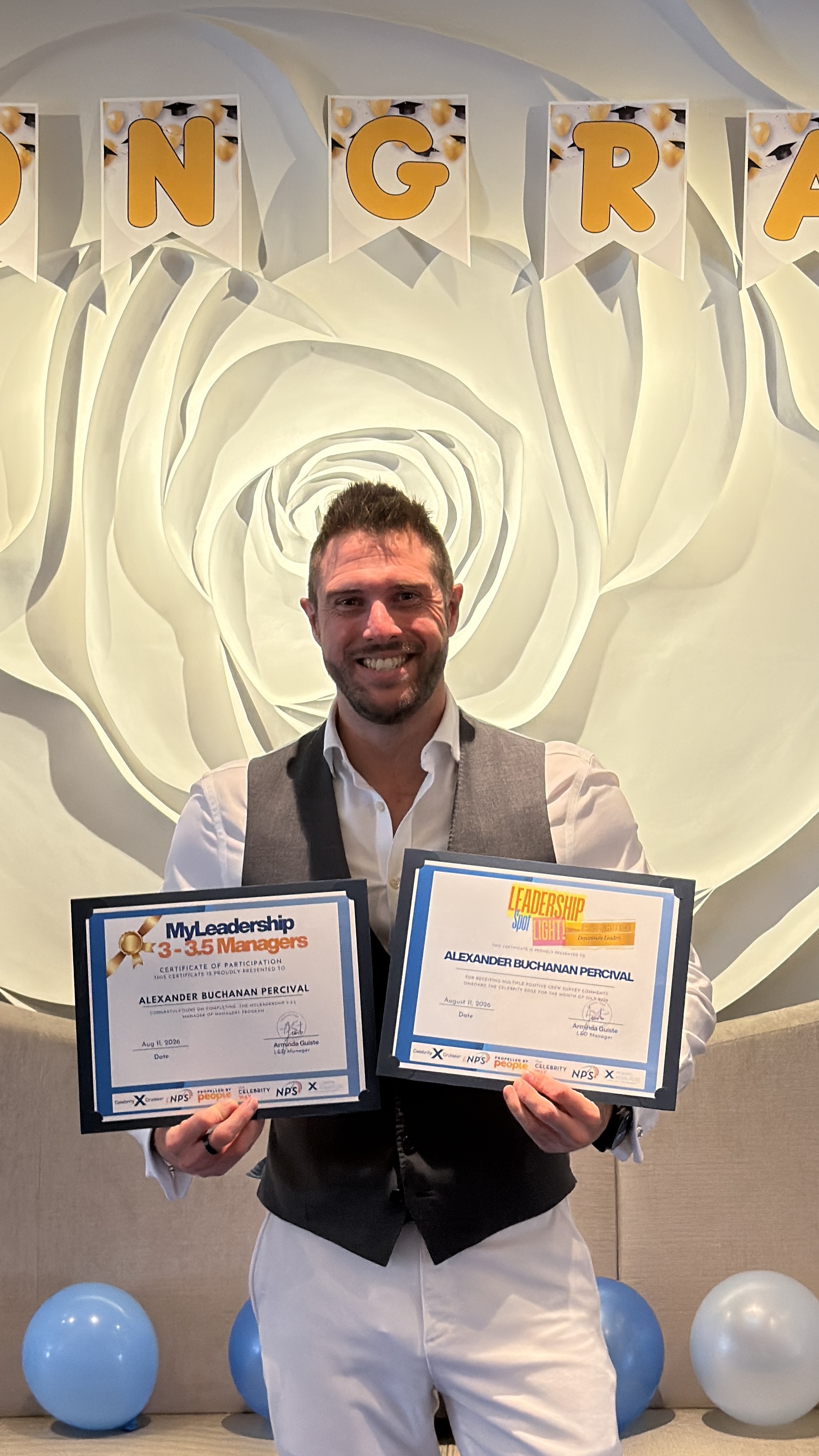 Alexander Percival holding MyLeadership and Leadership Spotlight certificates at an onboard recognition celebration